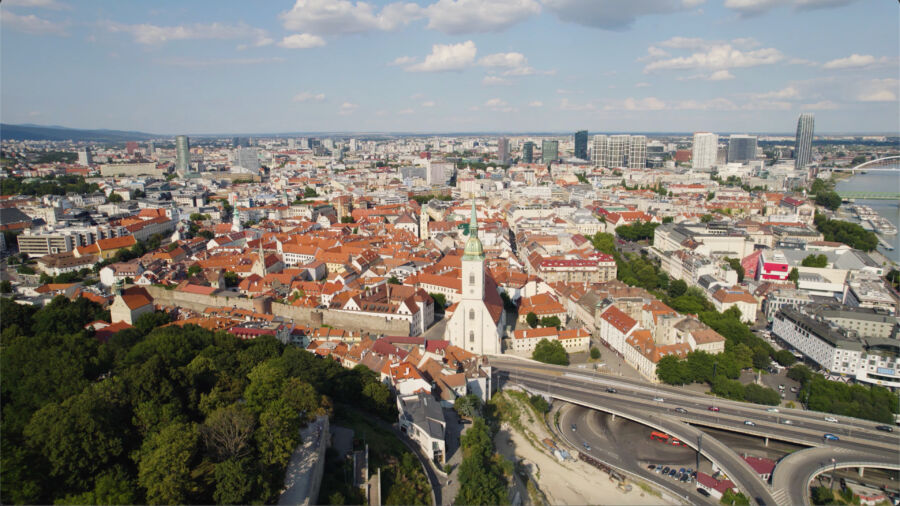 Aerial view of Bratislava cityscape showcasing St. Martin's Cathedral amidst urban buildings and green spaces