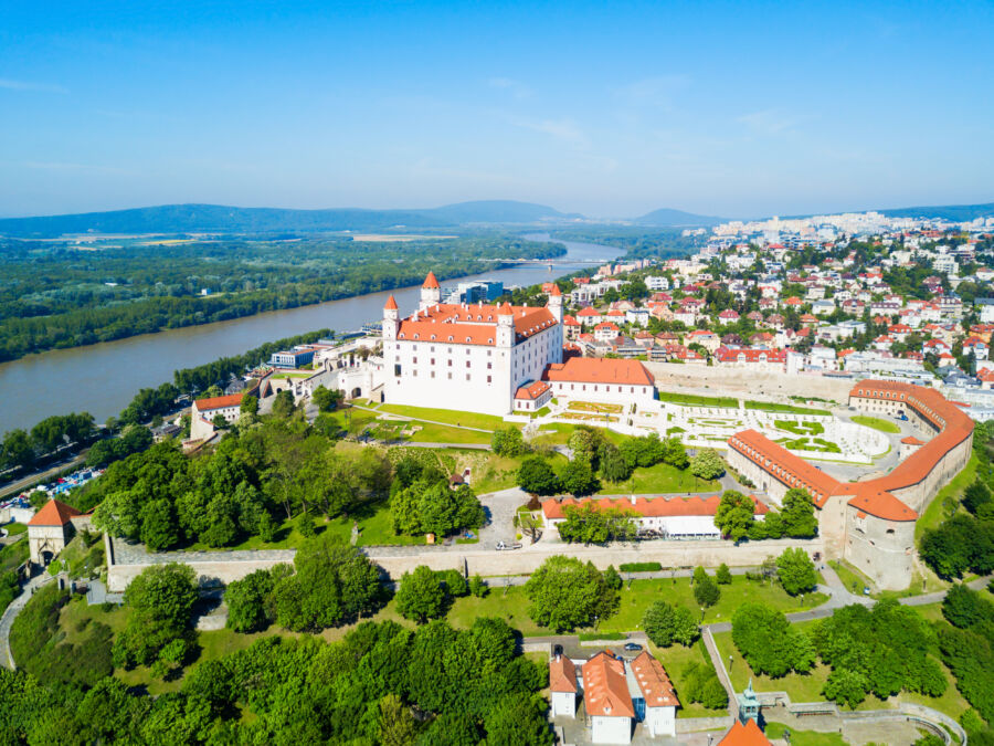Panoramic aerial view of Bratislava, Slovakia, featuring the skyline, the river, and notable historic architecture
