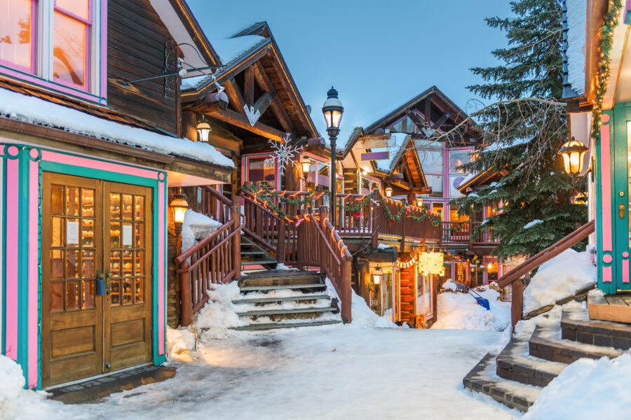 Colorful Christmas lights illuminate downtown Breckenridge, Colorado, creating a festive winter night scene.