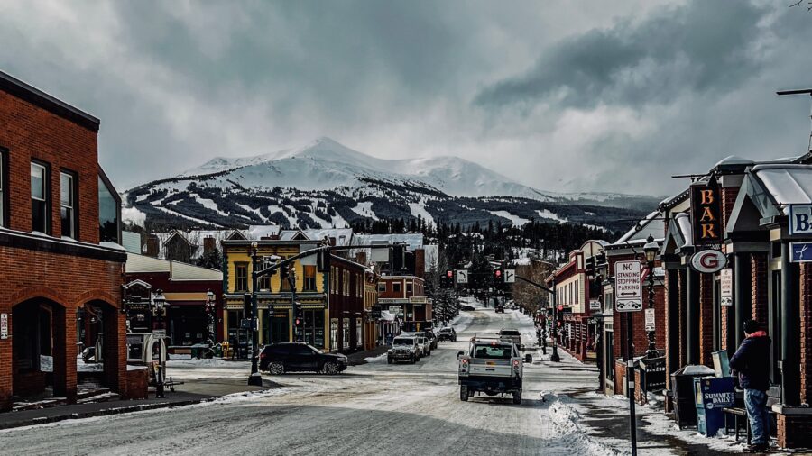 Snow-covered street shops in Breckenridge, Colorado, bustling with winter shoppers and festive decorations