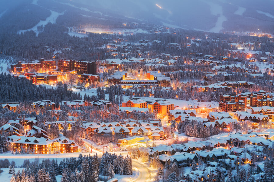 Scenic winter view of Breckenridge, Colorado, showcasing a snow-dusted town skyline with majestic mountains in the background