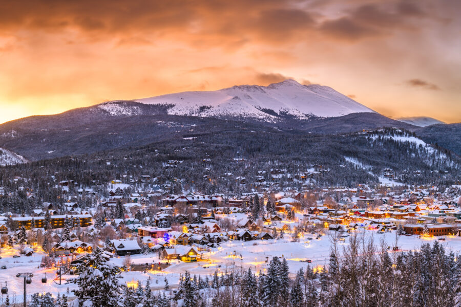 Scenic winter view of Breckenridge, Colorado, featuring a picturesque town skyline against a backdrop of snow-capped peaks