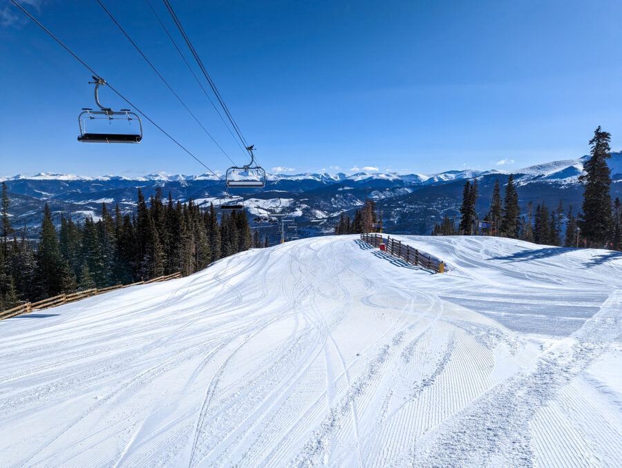 Bright sunny day at Breckenridge ski resort, showcasing ski lifts and snow-covered slopes
