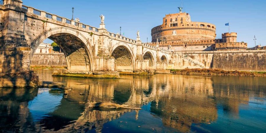 Tiber River with historic stone bridge and Castel SantAngelo fortress in Rome, reflected.