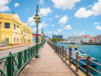 Scenic promenade along the marina in Bridgetown, Barbados, featuring palm trees and boats in the harbor