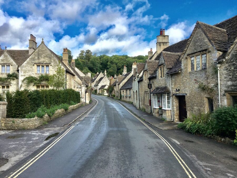 Picturesque view of a village street in Broadway , Cotswolds, England, featuring quaint cottages and scenic surroundings.