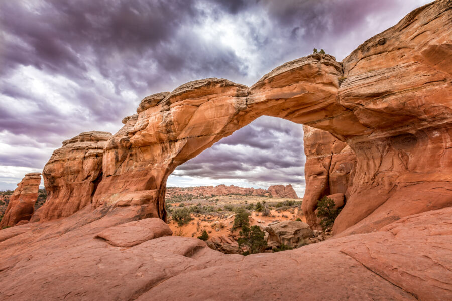 The iconic Broken Arch in Arches National Park, Utah, framed by desert landscape