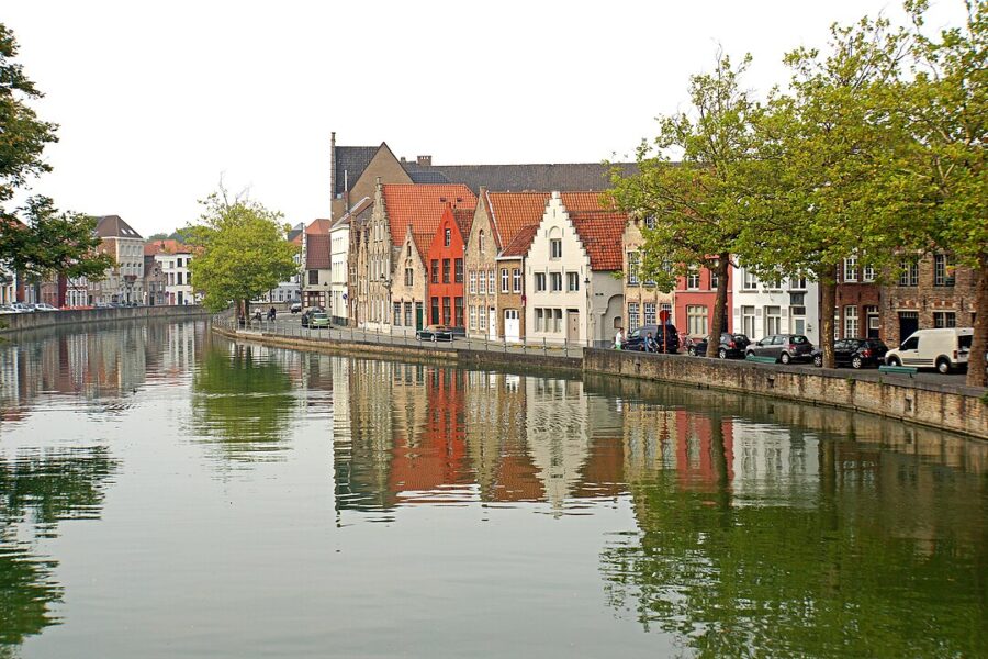 Scenic canal in Bruges City Center, Brussels flanked by historic buildings on both sides.