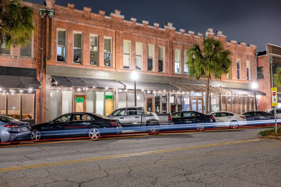 Night view of Brunswick, Georgia, featuring houses, parked cars, and a quiet street illuminated by streetlights