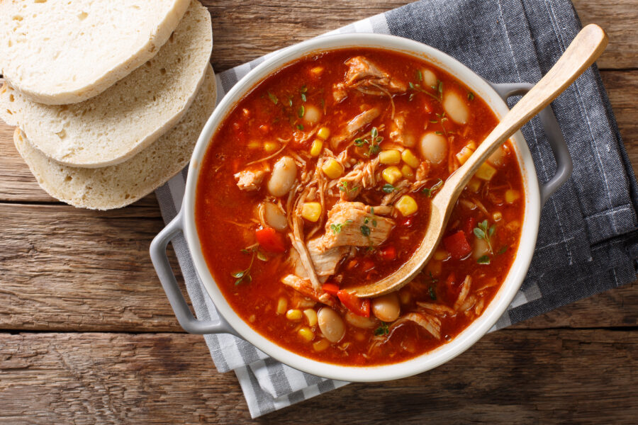 Close-up of Brunswick Stew in a pot, featuring pulled meat, vegetables, and a rich chicken broth with barbecue sauce