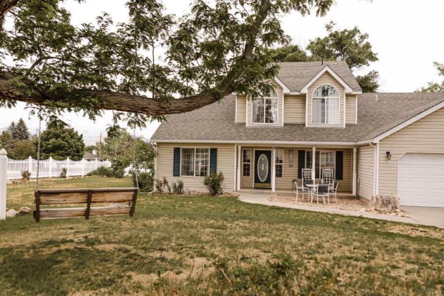 Spacious yard featuring a bench in front of a house at Bryce Pioneer Village, highlighting a serene outdoor setting.