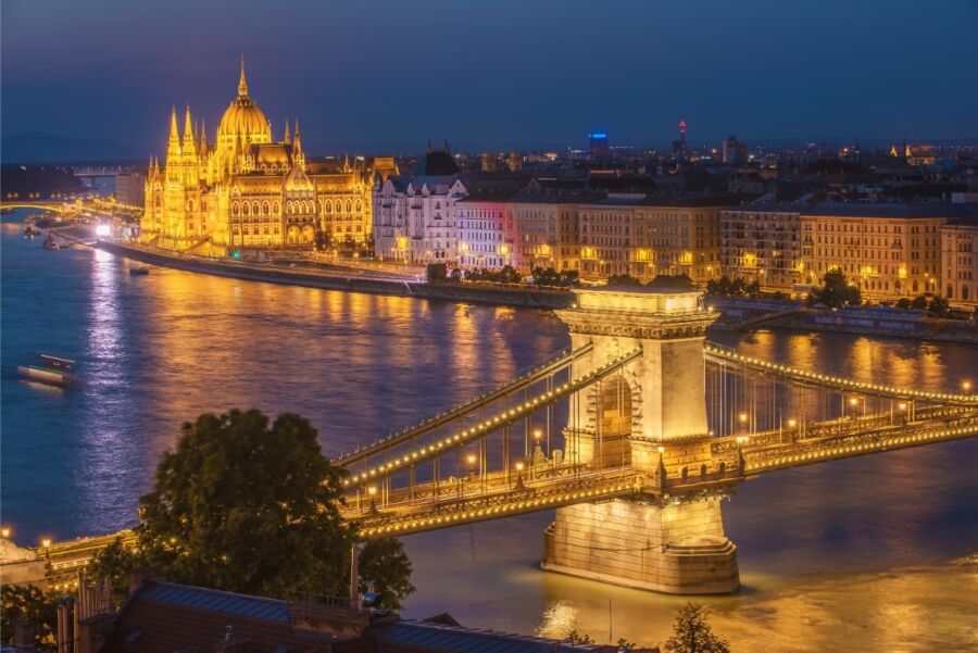 Aerial view of Budapest at night, featuring the city's glowing skyline and historic sites