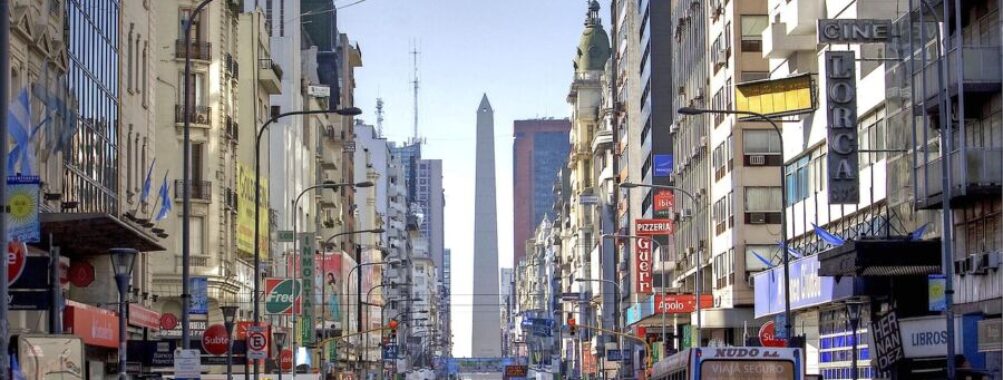 Bustling Buenos Aires street scene with the iconic Obelisco, historic and modern buildings, vibrant signage.