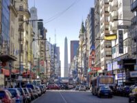 Bustling Buenos Aires street scene with the iconic Obelisco, historic and modern buildings, vibrant signage.