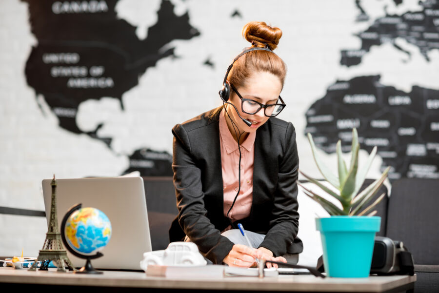 Busy professional travel agent on a business call in an office setting