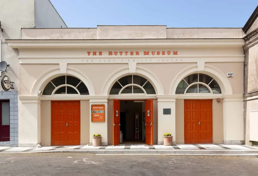 Butter Museum facade with orange doors and three arched openings.
