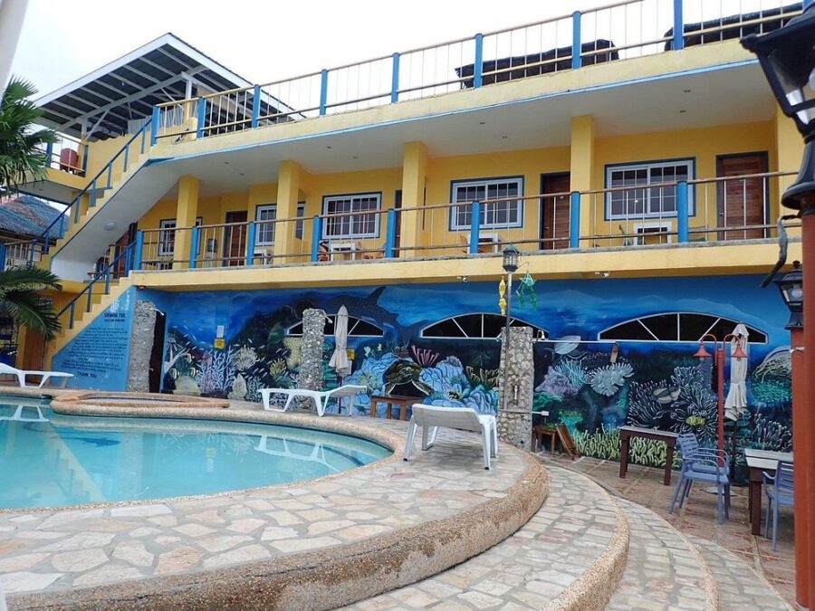 Cabana Beach Club Resort featuring a pool and a vibrant mural on its side, set against a clear blue sky.
