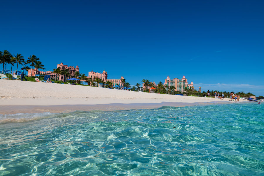 Panoramic view of Cabbage Beach in Paradise Island, featuring soft sand and vibrant blue ocean waves.