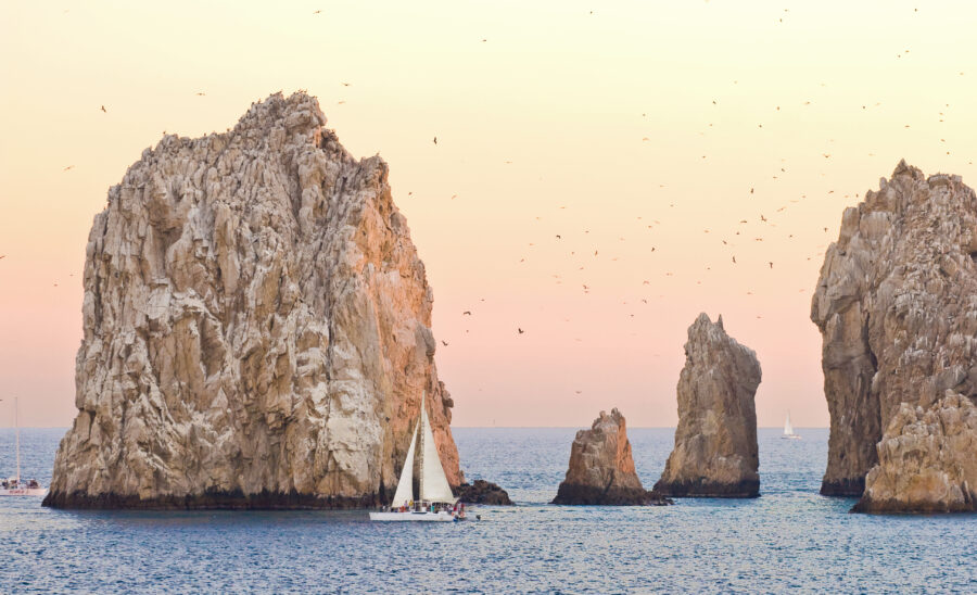 Rock formations at Cabo San Lucas, Mexico, showcasing unique geological shapes against a clear blue sky.