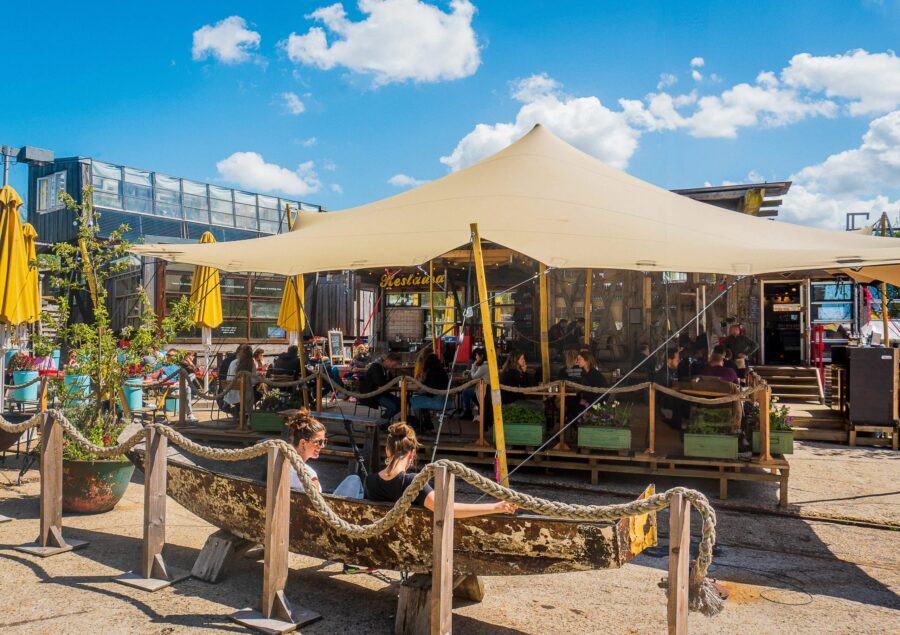 Large white tent set up at Café de Ceuvel in Amsterdam, providing a shaded area for outdoor activities.