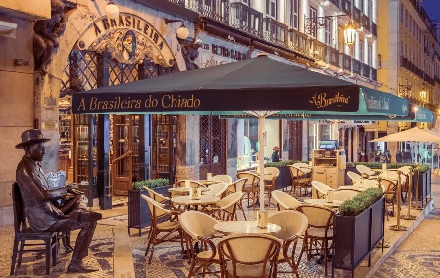 A Brasileira café terrace in Chiado, Lisbon, bronze statue and outdoor seating.