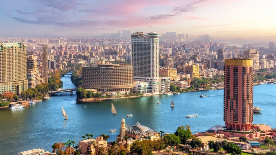 Cairo skyline: Nile River, modern skyscrapers, historic architecture, and serene morning glow.