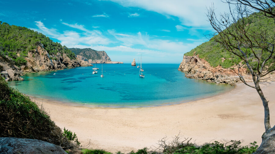 Cala Benirrás in Ibiza, known as Finger of God, features stunning cliffs and a picturesque beach setting