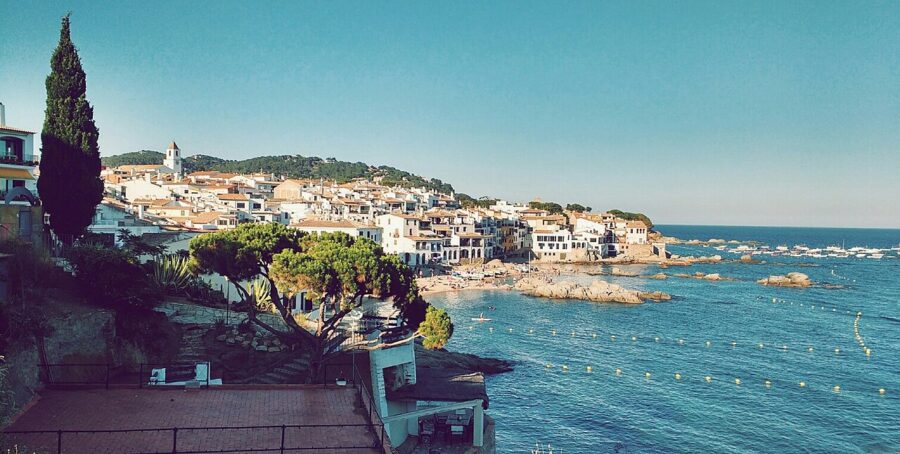 Scenic view of Calella de Palafrugell, Spain, showcasing boats on the water with the coastal town in the background.