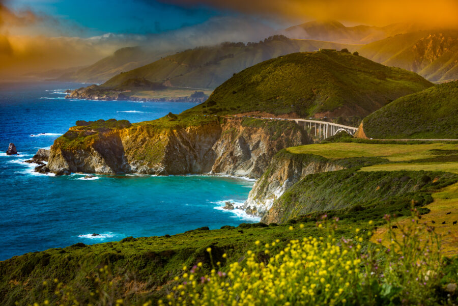 The iconic Bixby Creek Bridge in Big Sur, California, features a graceful arch over a lush canyon with ocean views.
