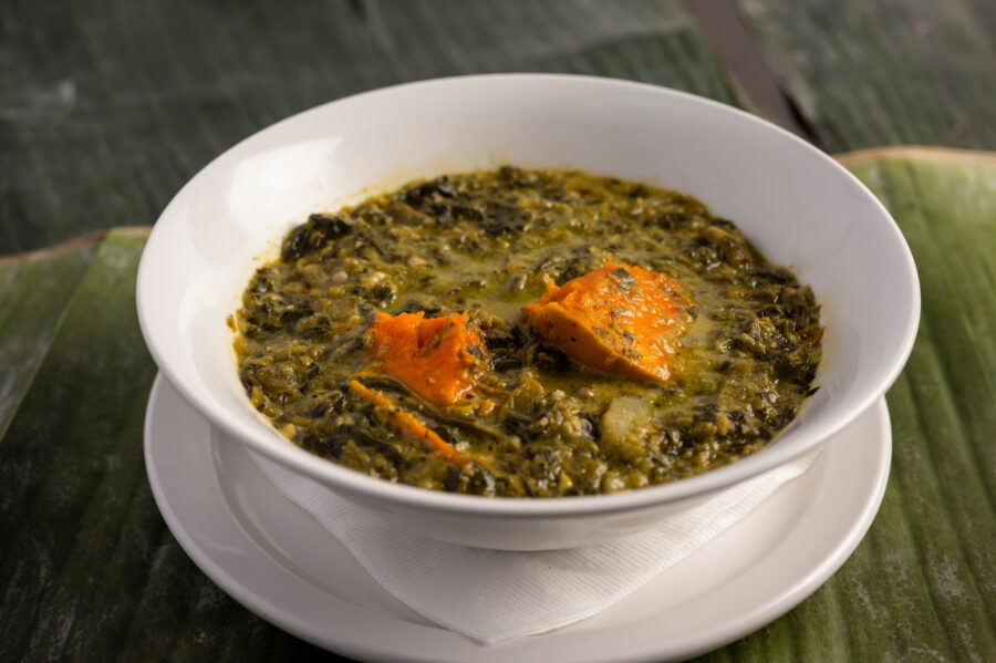 Close-up of a bowl filled with vibrant green Callaloo, showcasing its fresh, leafy texture and rich color