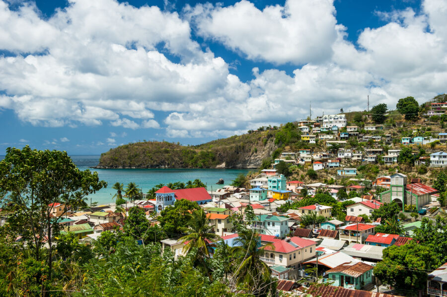 Vibrant Village of Canaries in Saint Lucia, featuring charming houses and a backdrop of green hills and blue skies