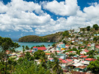 The Village of Canaries in Saint Lucia, featuring vibrant houses nestled among green hills and the Caribbean Sea.