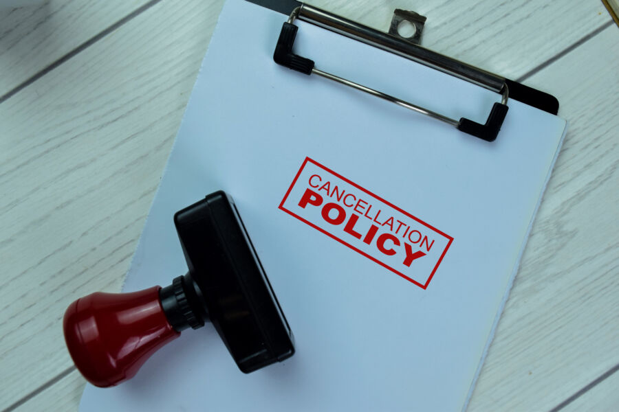 Red handle rubber stamper with text detailing the cancellation policy prominently displayed