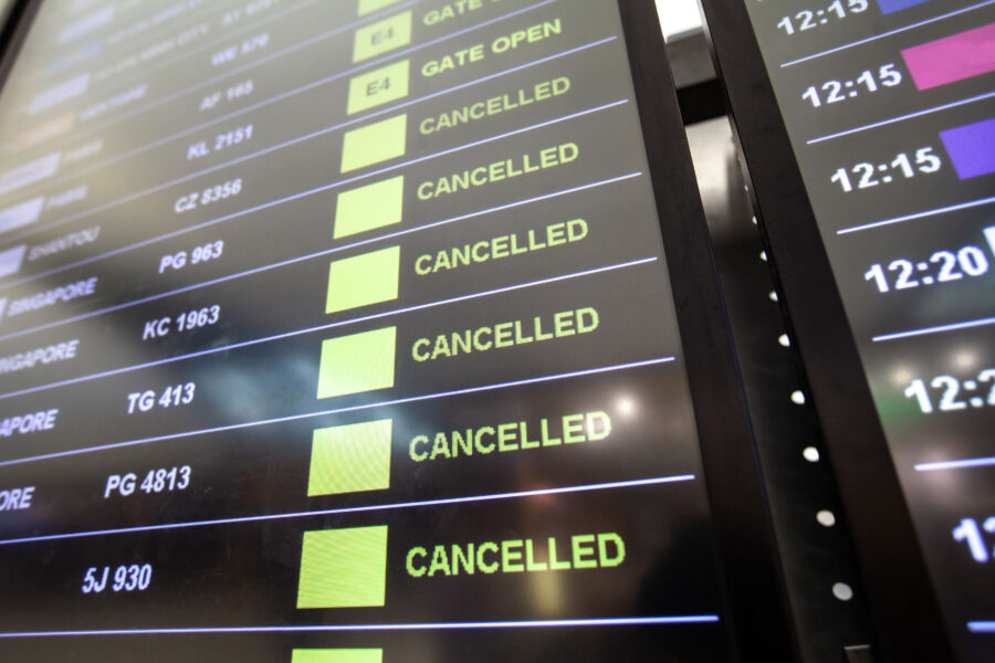 Flight cancellations displayed on an airport departure board, indicating multiple flights are delayed or canceled