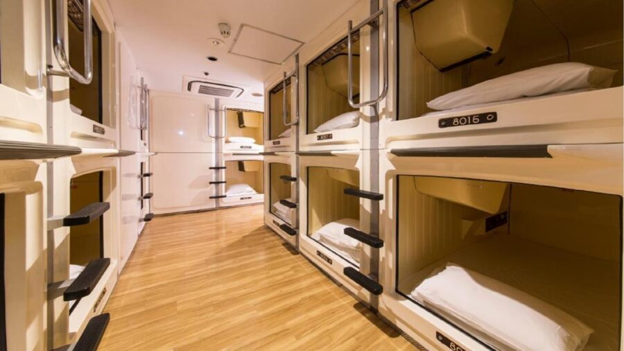 Modern minimalist capsule hotel interior with sleek design, soft lighting, and cozy sleeping quarters.