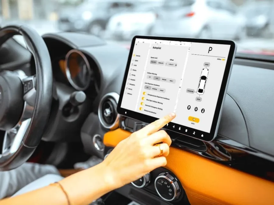 Car autopilot touchscreen settings on modern dashboard with hand adjusting controls.