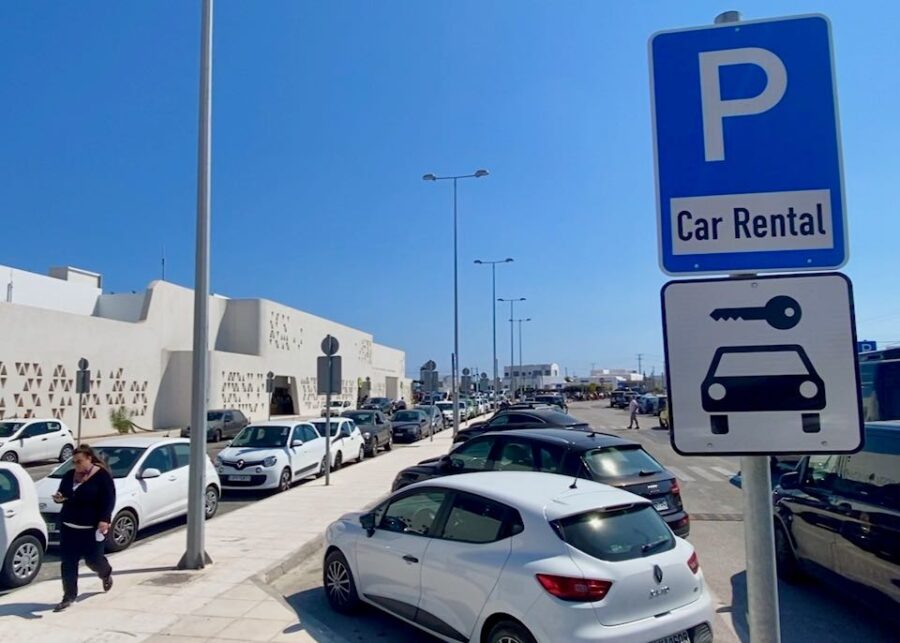 Car rental facility near Mykonos Airport with modern design and parked rental cars.