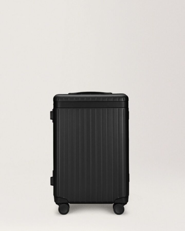 Black Carl Friedrik Carry-on X suitcase with wheels on a white background.