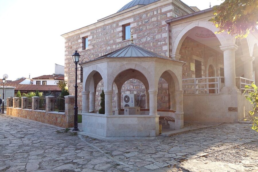 Sstone building with a clock, located in Čaršija, Skopje, Macedonia, showcasing historical architecture.