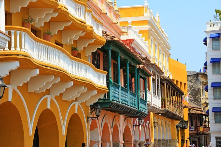 Colonial architecture with colorful facades and balconies in a vibrant Latin American street scene.