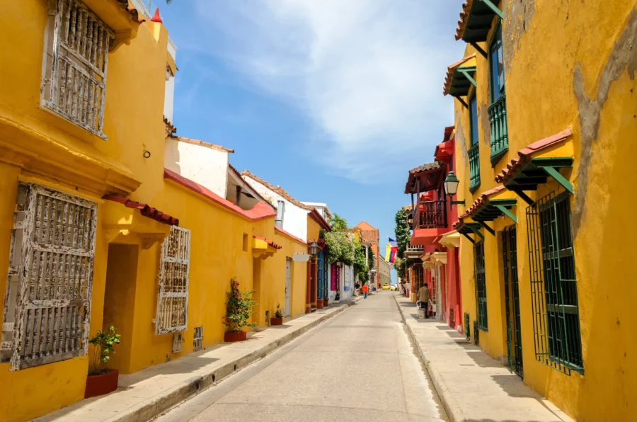 Vibrant Cartagena street scene with colorful architecture, cobblestones, and lively atmosphere.