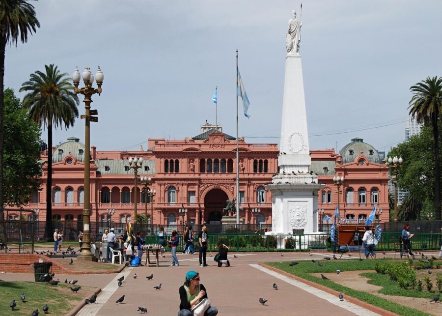 Casa Rosada in Buenos Aires: vibrant square with obelisk, Argentine flag, and bustling activity.