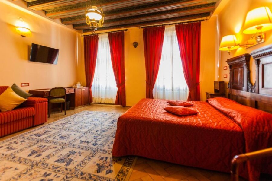 Hotel room at Casa Wagner in Brasov featuring a bed and red curtains.