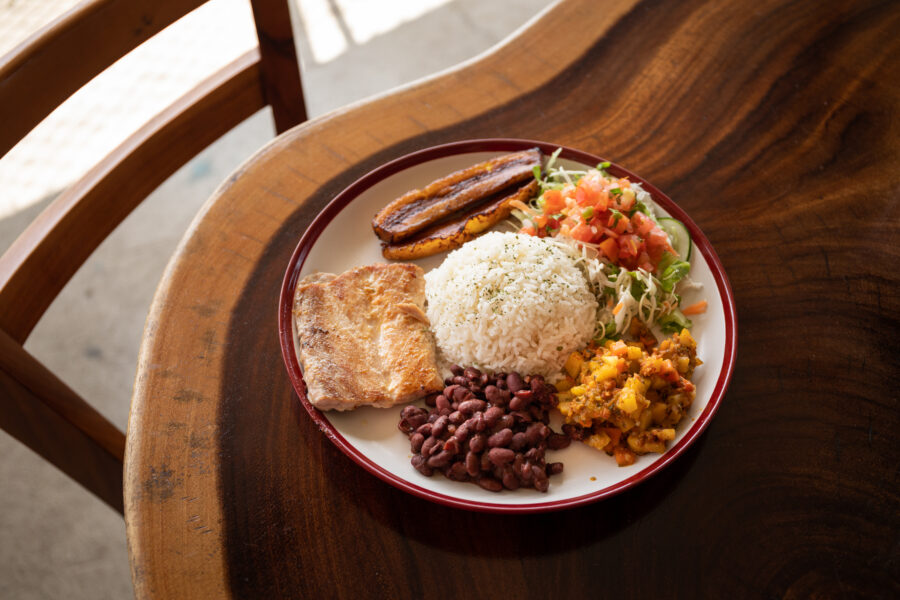 Traditional Costa Rican Casado meal featuring rice, beans, plantains, salad, and a protein, served on a colorful plate