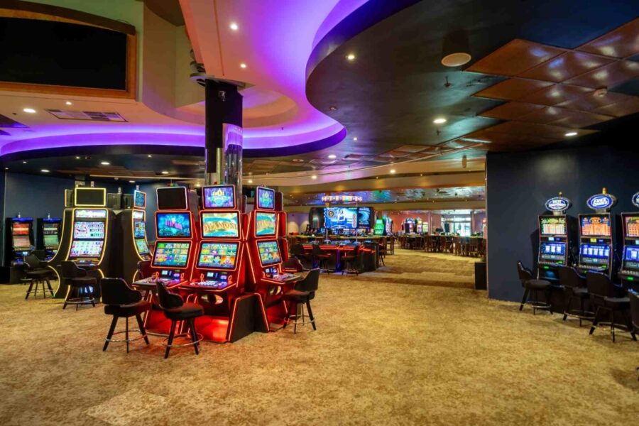 Interior view of Casino Royale St Maarten, showcasing a lively casino room filled with slot machines and gaming tables.
