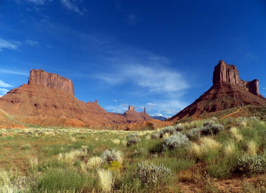 Red rock formations of Monument Valley, Utah, showcasing towering cliffs and unique geological structures against a clear sky.
