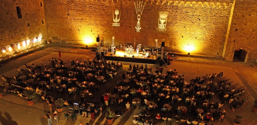 Outdoor concert at historic stone wall during Brunello Wine Festival.