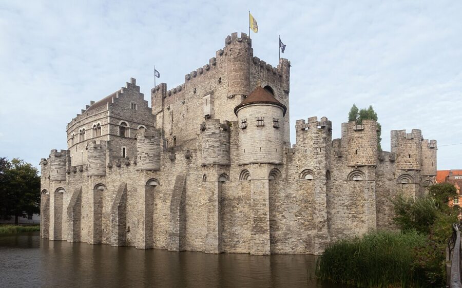 The Castle of the Counts in Gent, a stone fortress with a surrounding moat, exemplifying classic medieval design.
