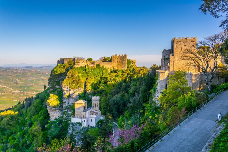 Medieval castle on green hill, Erice, historic architecture, nature harmony.