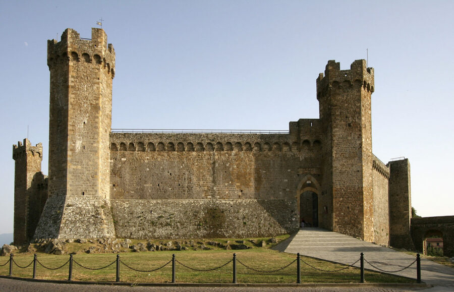 Medieval stone castle with towers, crenellated parapets, grand entrance, and scenic landscape.